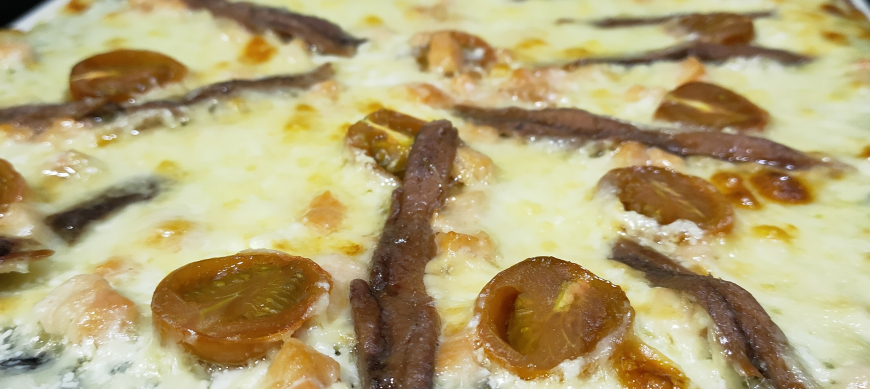 Pizza de carbón vegetal con nata y ahumados